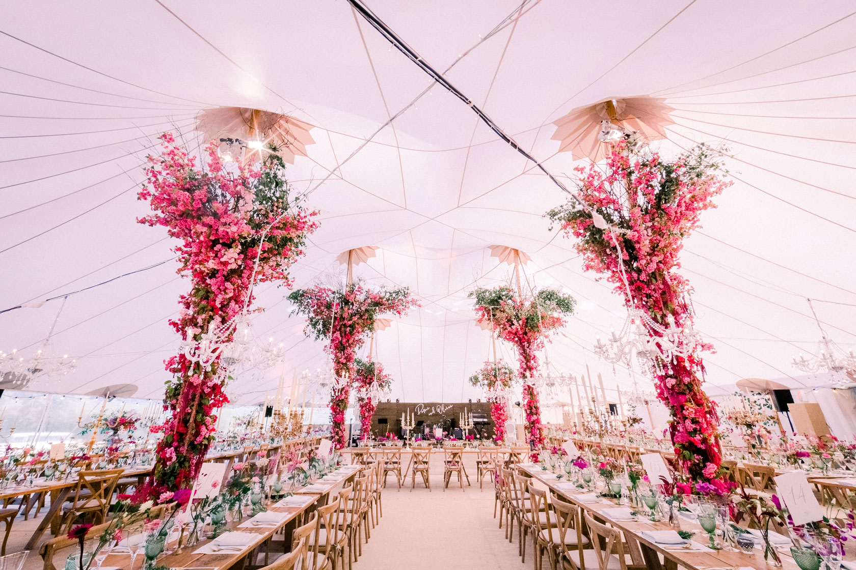 Soho Farmhouse wedding breakfast with huge pink floral columns from floor to ceiling inside a marquee