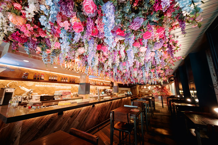 flowers hanging from the ceiling inside a restaurant