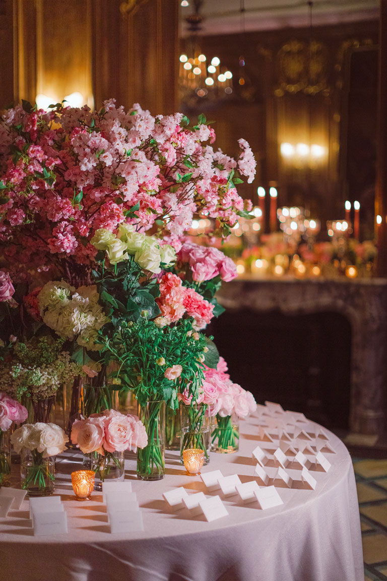 an escort table arrangement with flowers and candles