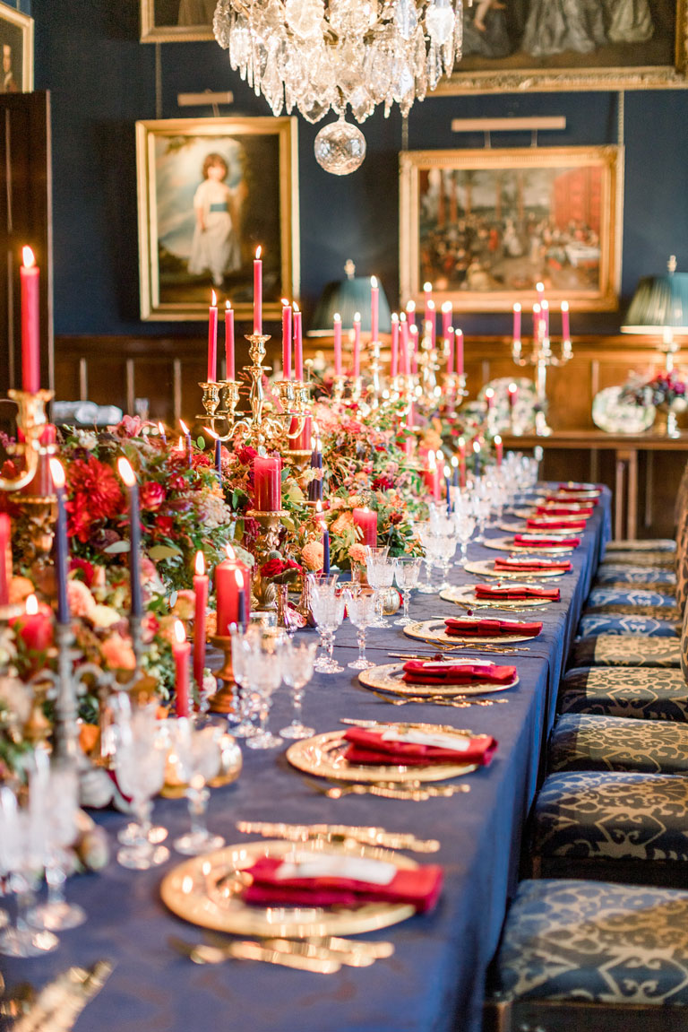 eastnor castle regal ornate navy and gold wedding breakfast with red candles, gold plates