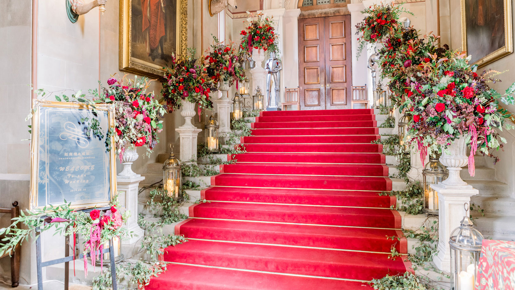 a castle staircase with an avenue or urns and plynths filled with flowers on each step